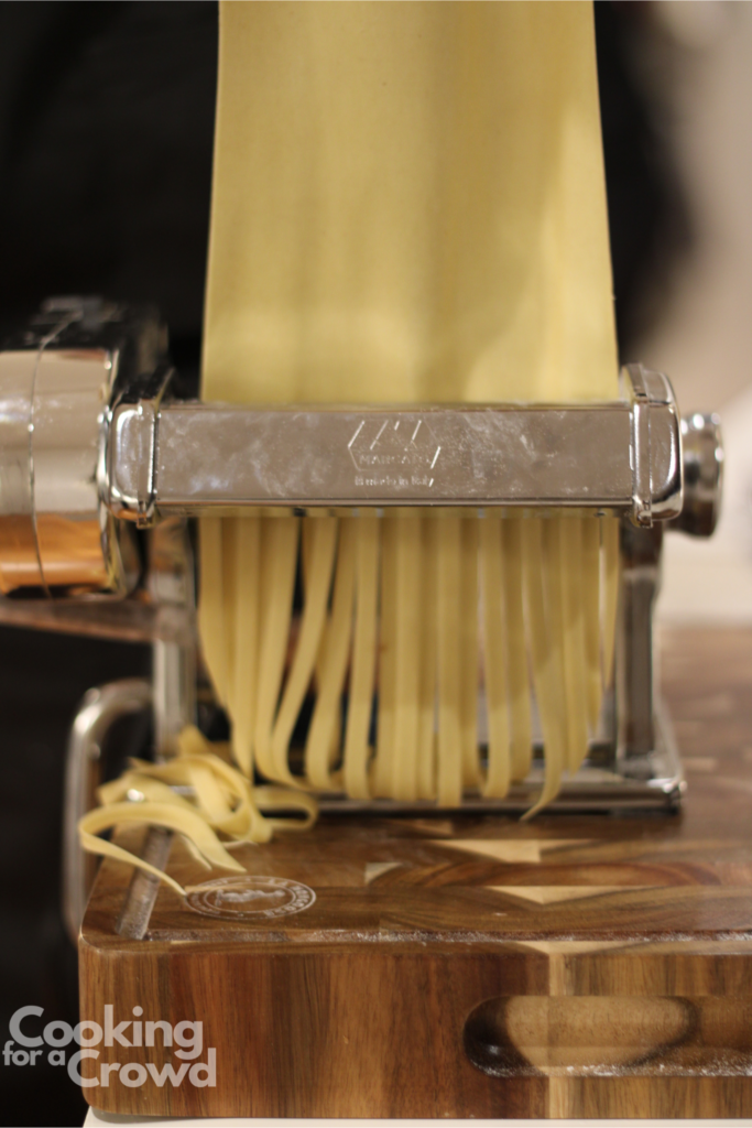 Cutting the pasta into fettuccini noodles.